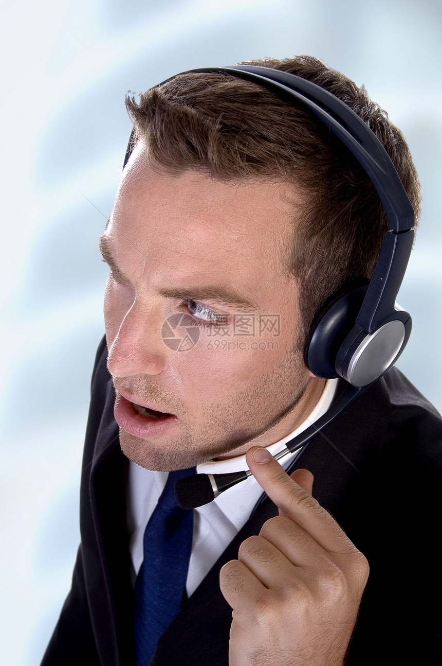 带耳机的有技术的青年商务人士图片