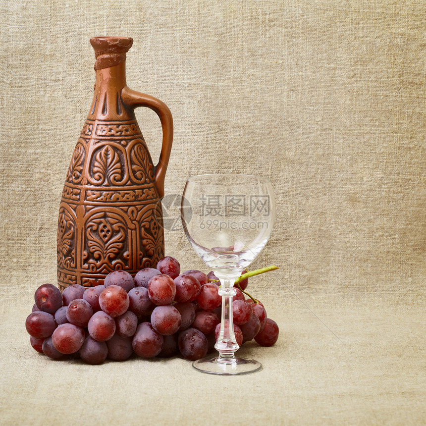 粘土瓶 葡萄和在画布上的玻璃杯图片