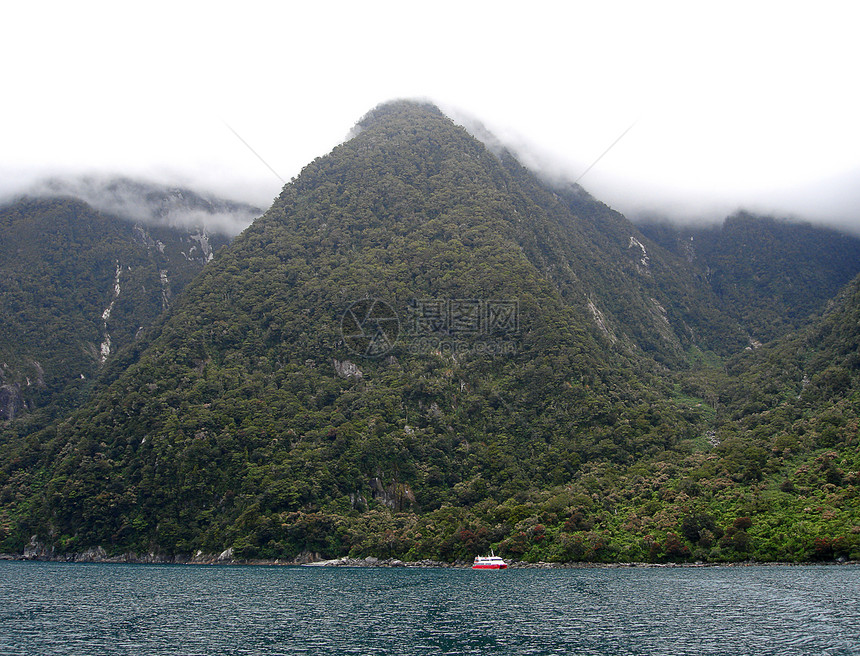 新泽州密尔福德湾内穿越山区的旅游船图片