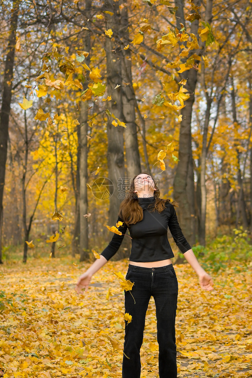 秋天公园的女孩闲暇女性阳光青年森林树叶季节幸福微笑喜悦图片
