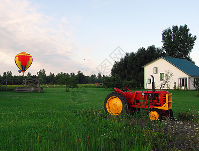 红色和黄色气球热气气球和拖车运输篮子天空拖拉机红色娱乐空气绳索农场场地背景
