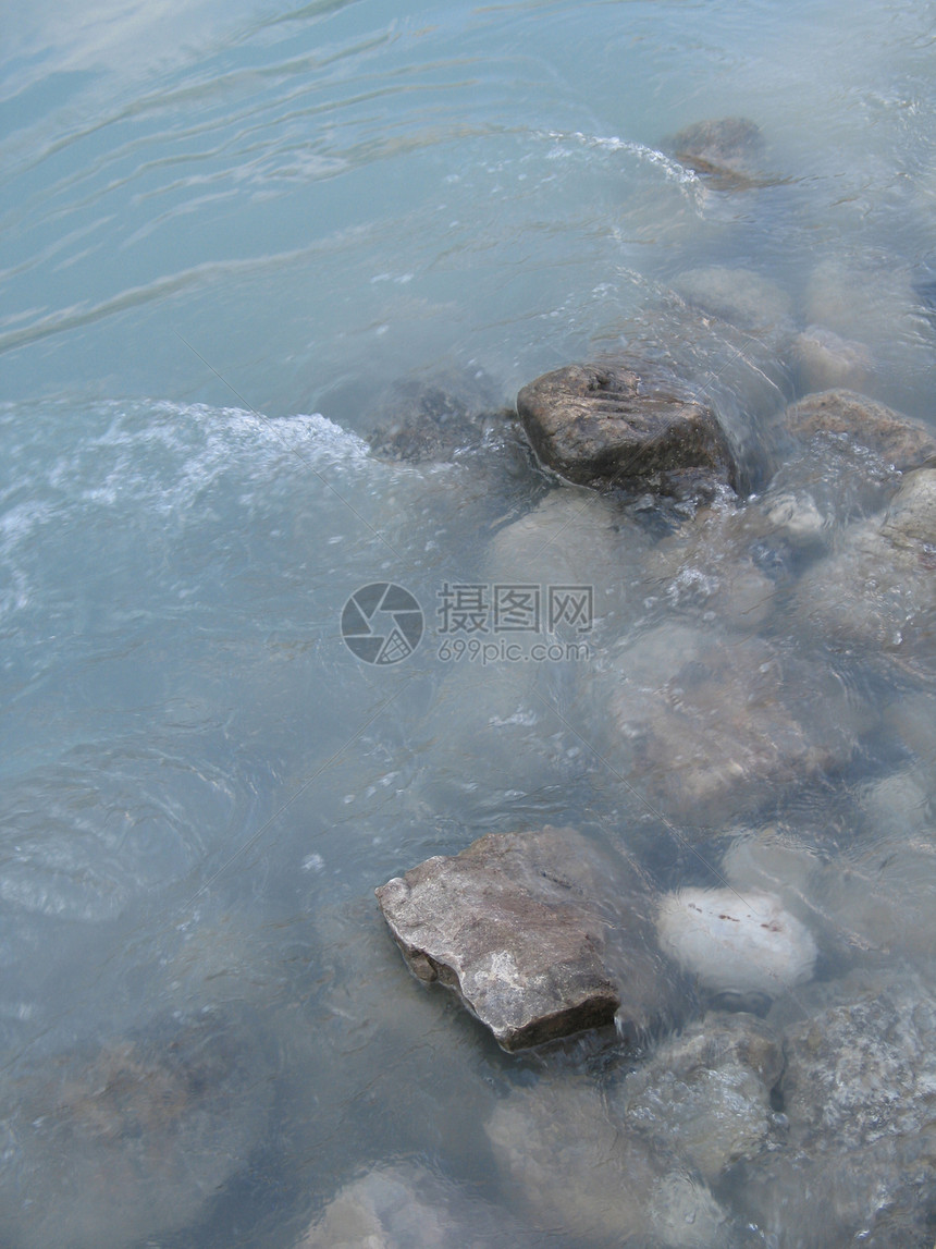 灰色抛光岩石和绿河水扣篮石头蓝色绿色溪流反射图片