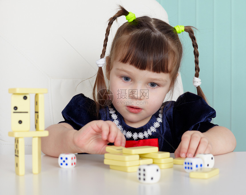 儿童在餐桌上玩小玩具孩子裙子童年座位骨牌白色团体桌子手指婴儿图片