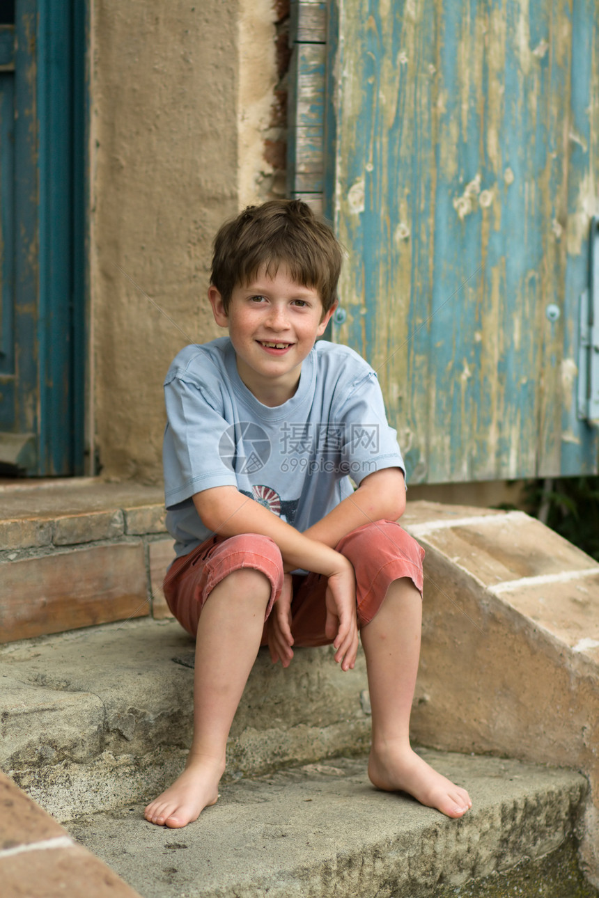 微笑的男孩坐在台阶上图片