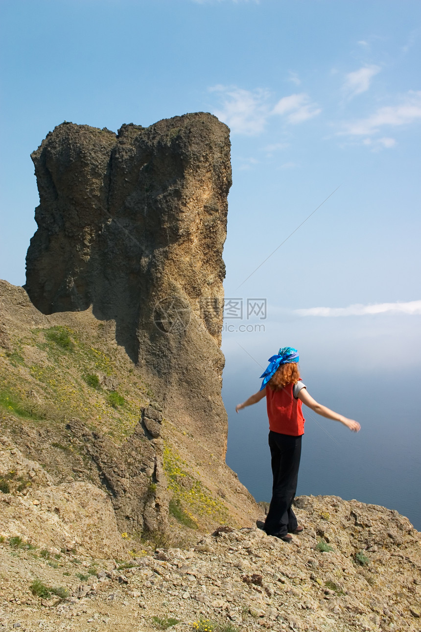 女孩在海边的岩石上图片