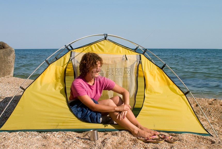 坐在海边帐篷里的闪烁着微笑的女孩图片
