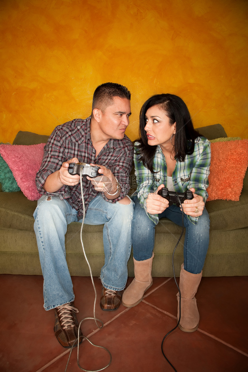 西班牙裔情侣玩视频游戏牛仔布电脑男朋友妻子电视成人长椅电缆女性优胜者图片