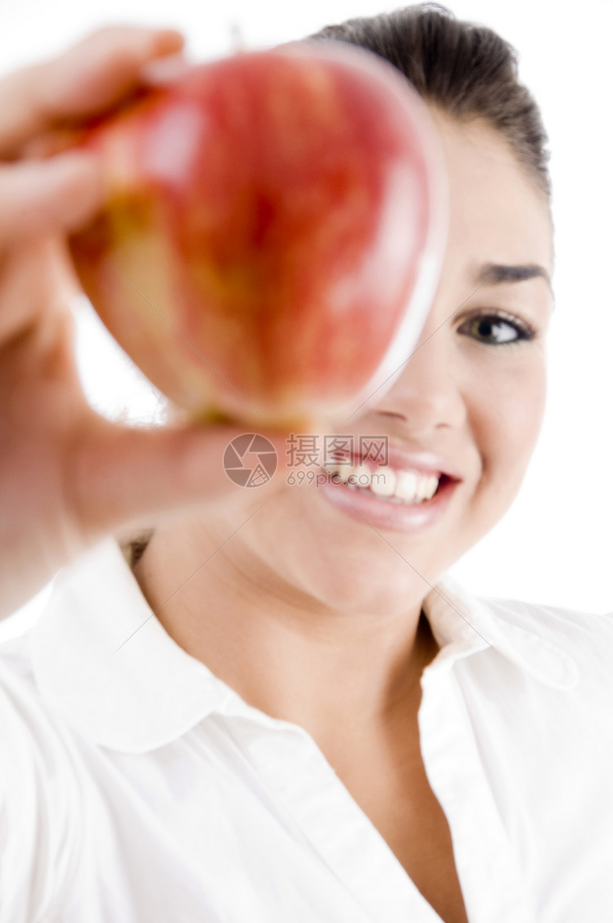 美丽的年轻女子微笑并握着一个苹果图片