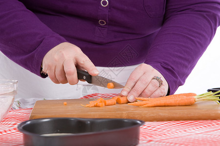 砍胡萝卜准备萝卜蔬菜女士厨房工作木板厨师背景图片