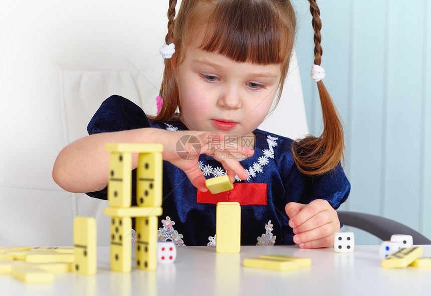 玩多米诺游戏的儿童蓝色孩子桌子柜台骨头白色童年女孩骰子骨牌图片