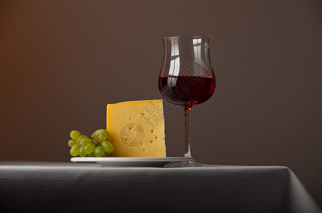 一块奶酪 一堆葡萄和红酒奶制品用餐饮料桌子桌布美食熟食酒精酒杯反射背景