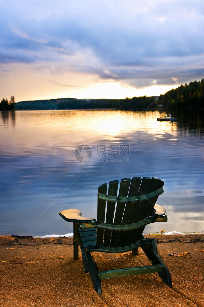 海滩日落时的木椅子反射支撑反思天空荒野树木国家小屋风景日出图片