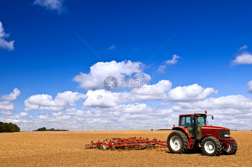 犁田中的拖拉机收获场景土地培育地平线商业栽培天空收成农场图片