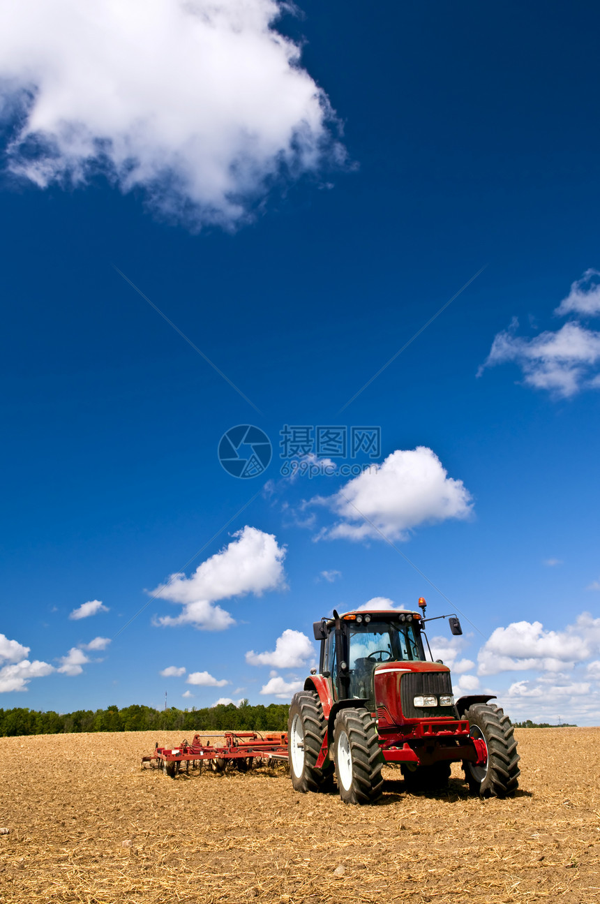 犁田中的拖拉机农业土地地球天空地平线耕作商业机械农场耕种图片