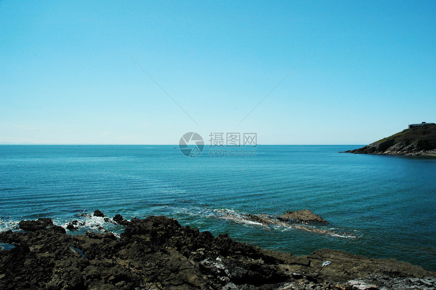 东海海滩边缘石头蓝色爬坡绿色悬崖天空岩石图片