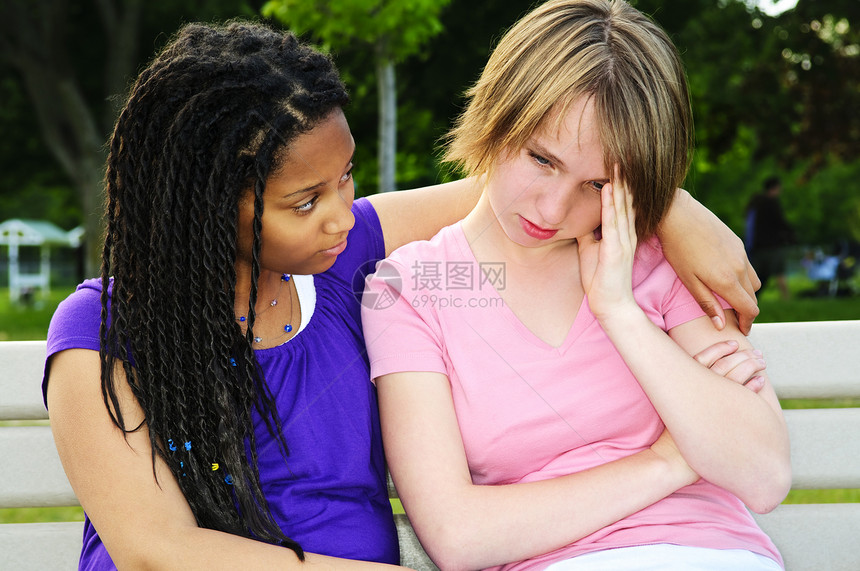 年轻人安慰她的朋友帮助哭泣朋友们友谊女孩们黑色女孩情绪化长椅多样性图片