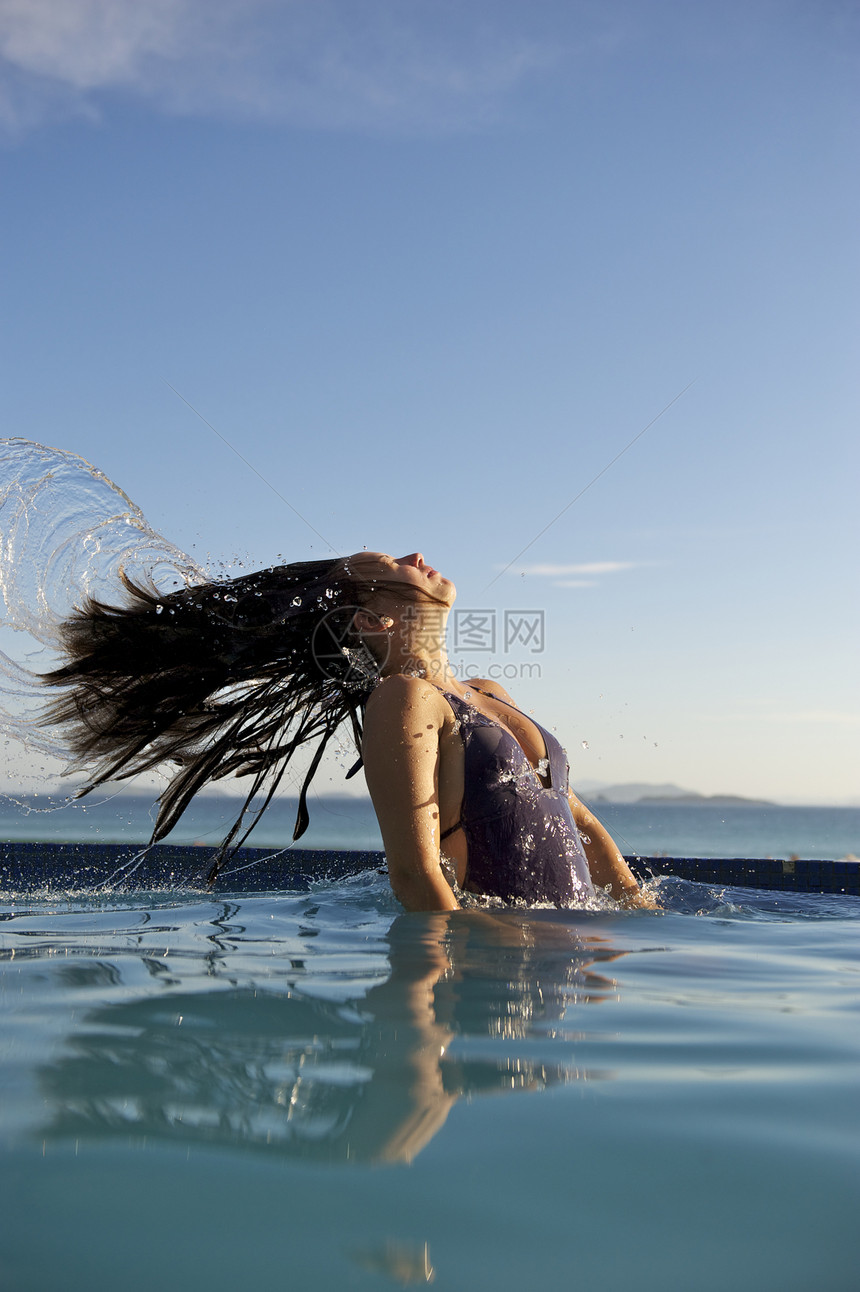 女人在游泳池里放松自由假期享受活动成人女性禅意反射蓝色游泳衣图片