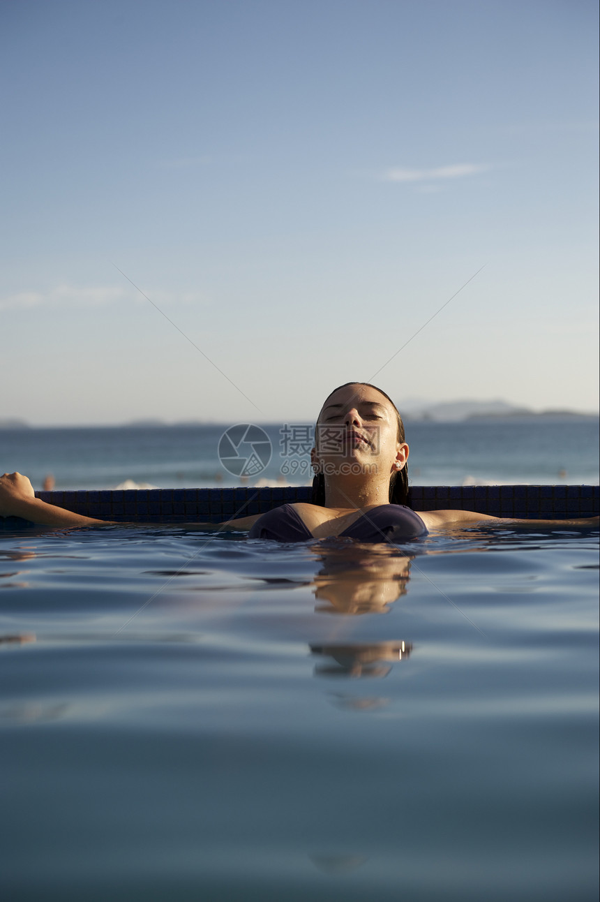 女人在游泳池里放松自由享受生活方式成人禅意游泳衣蓝色旅行假期活动图片