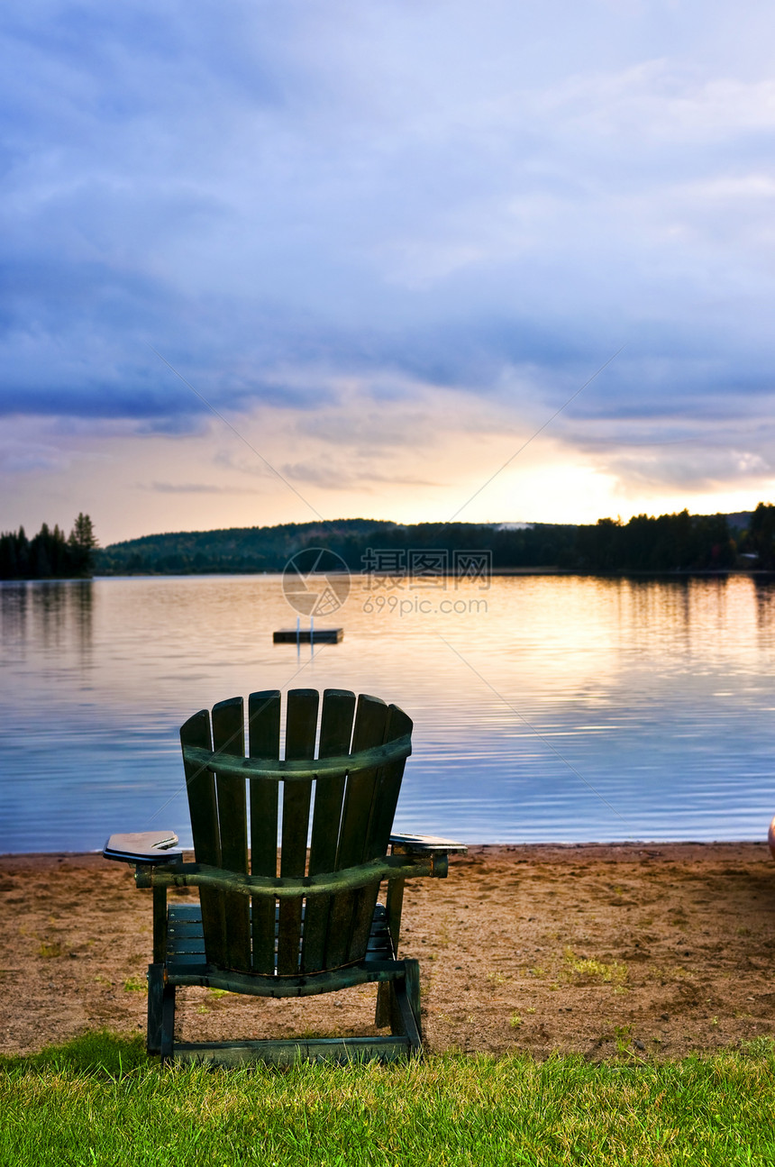 海滩日落时的木椅子假期家具国家天空反射小屋日出风景荒野公园图片