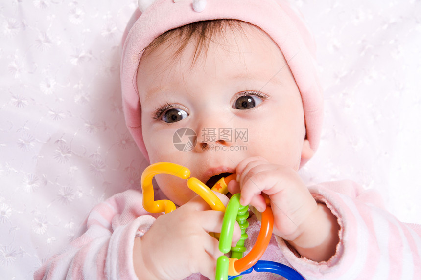 带玩具的婴儿棕色说谎帽子眼睛女孩咀嚼粉色图片