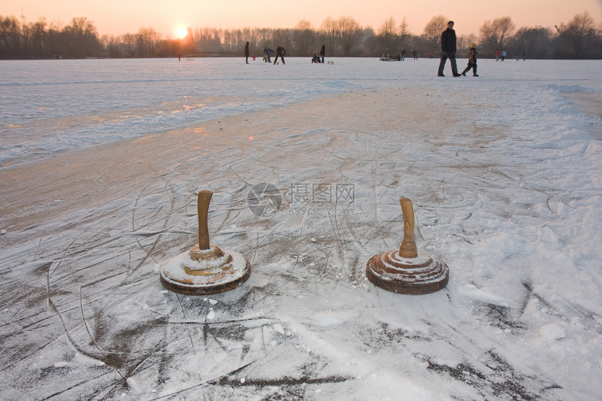 日落时在冰冻的湖边两块圆石划痕行动团队石头运动活动娱乐游戏图片