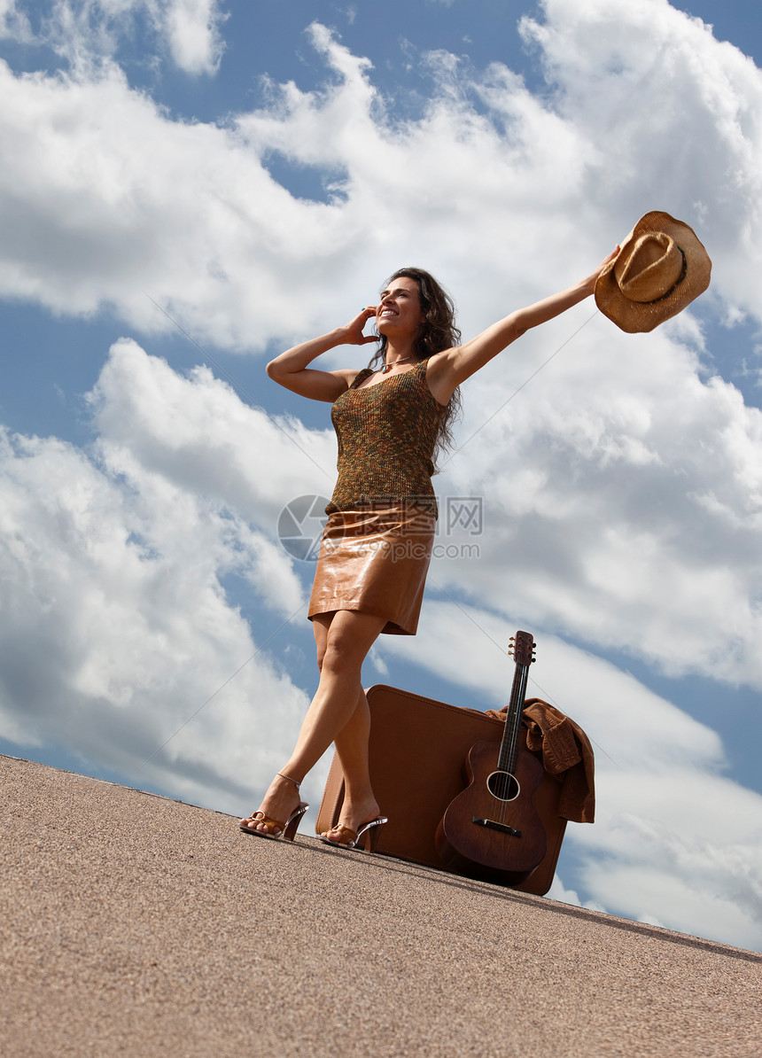 穿手提箱和吉他的漂亮女人手提箱手臂天空原住民脚跟牛仔乐器女性微笑民间图片