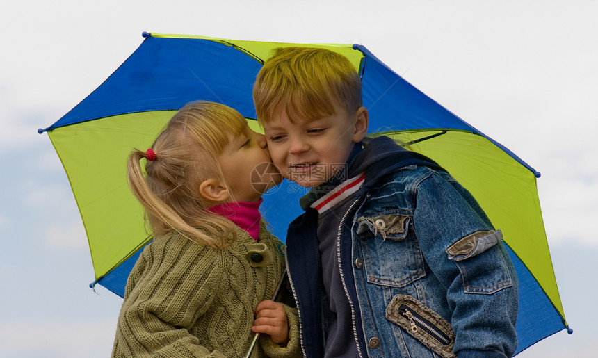 带伞的小男孩女孩阴影友谊乐趣孩子们兄弟阳光晴天蓝色天空情感图片
