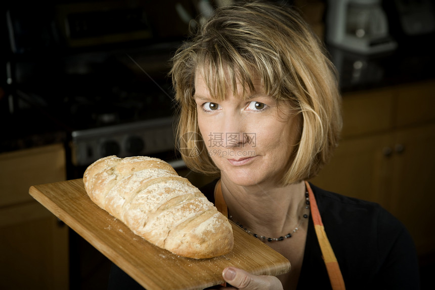 厨房里的女人和面包成人金发女郎房子烹饪快乐女性食物微笑面粉面包师图片