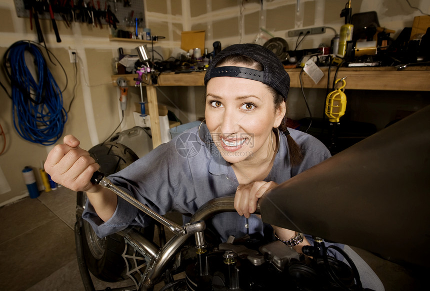 西班牙裔女性技工c帽子扳手引擎工具微笑运输摩托车菜刀金属女孩图片