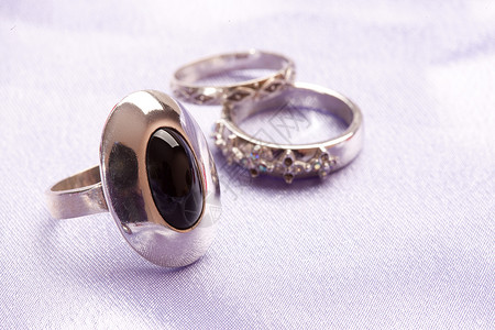 戒指女性配饰黑色宝石石头布料纺织品背景图片
