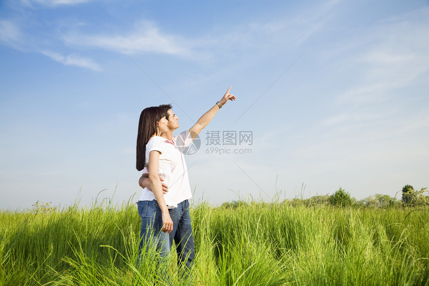 草地女士拥抱微笑女朋友手指女性男性幸福团结年轻人图片