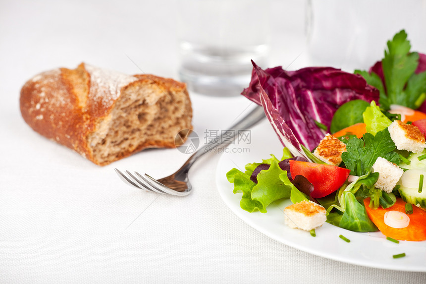 白盘上加叉子的混合沙拉白色莴苣菊苣戒指长叶正方形洋葱蔬菜韭菜面包块图片