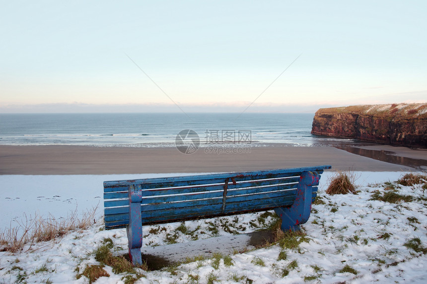 沙滩和悬崖的倾斜冬季长椅图片