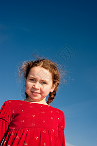 穿红裙子的年轻女孩 看着镜头蓝色微笑喜悦女儿天空姐姐红色青年公园孩子背景图片