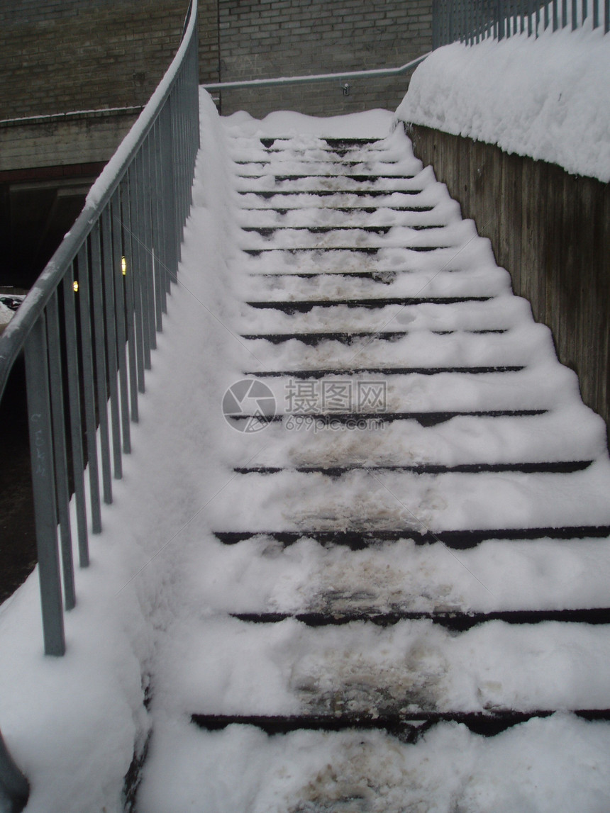 铺有雪雪的楼梯棕色白色脚印栏杆图片