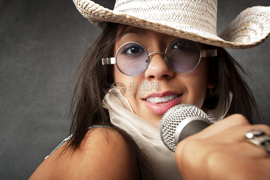 美丽的年轻歌手演员唱歌流行音乐太阳镜围巾成人女性麦克风帽子岩石图片