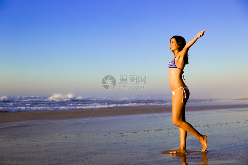 女人在沙滩上身体享受旅行喜悦天空成人太阳女孩海洋活力图片