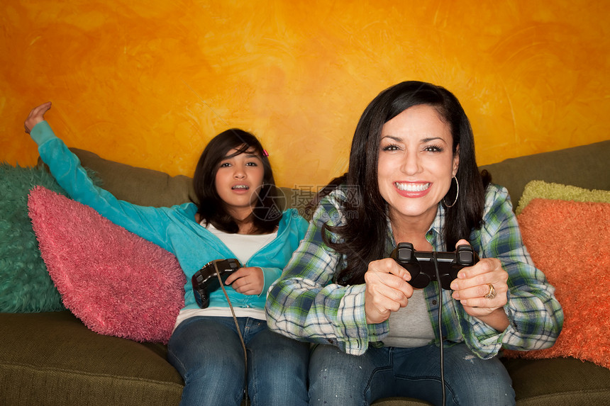 西班牙裔妇女和女孩玩视频游戏游戏Name乐趣长椅竞赛孩子母亲格子微笑失败者女性控制器图片