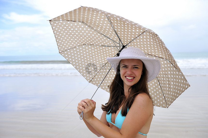 享受海滩太阳阳伞比基尼海岸热带女孩日光浴旅行天堂假期图片