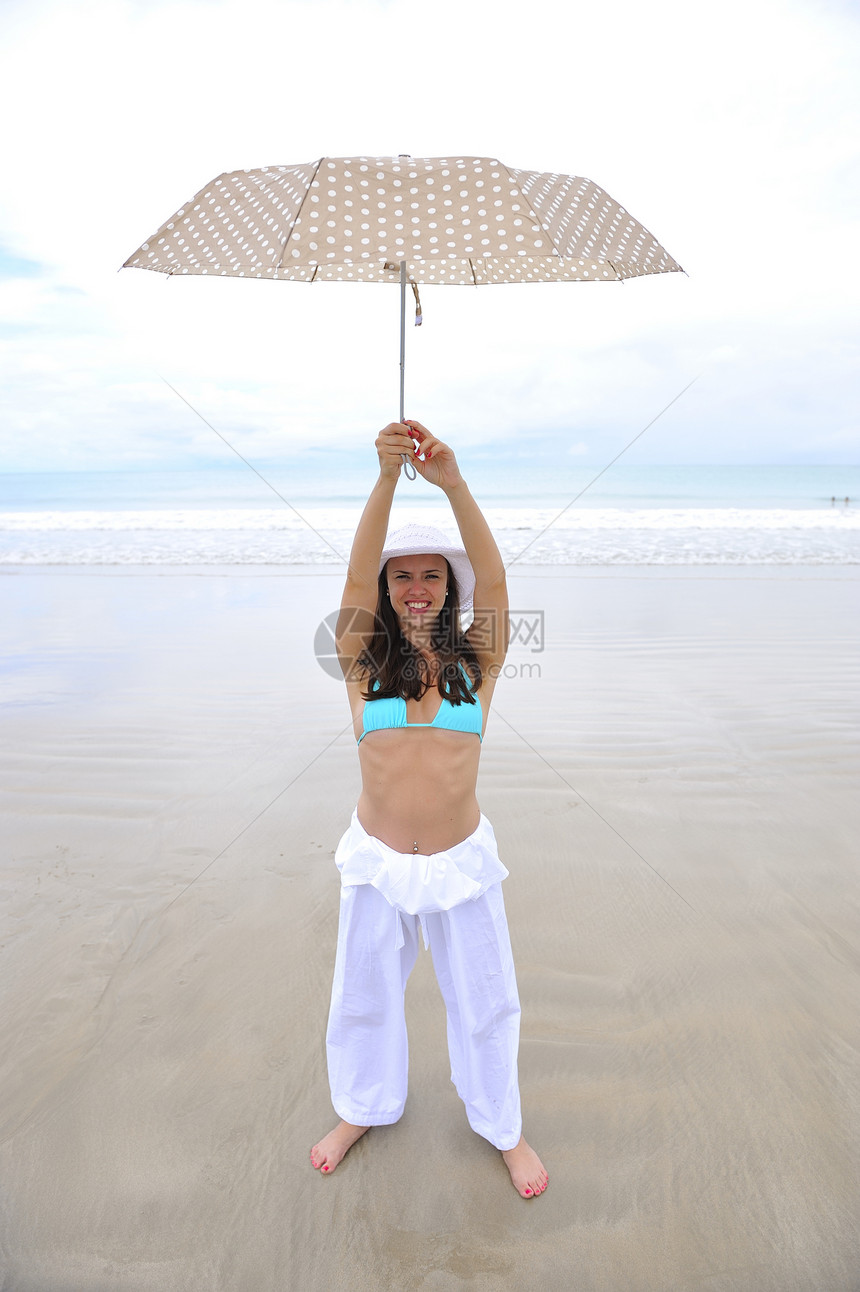 享受海滩热带海洋海岸日光浴天堂太阳游客女孩旅行阳伞图片