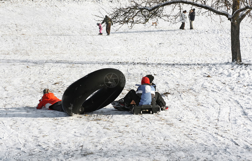冬季儿童晴天驾驶白色橡胶管雪橇风景平底乡村山坡图片