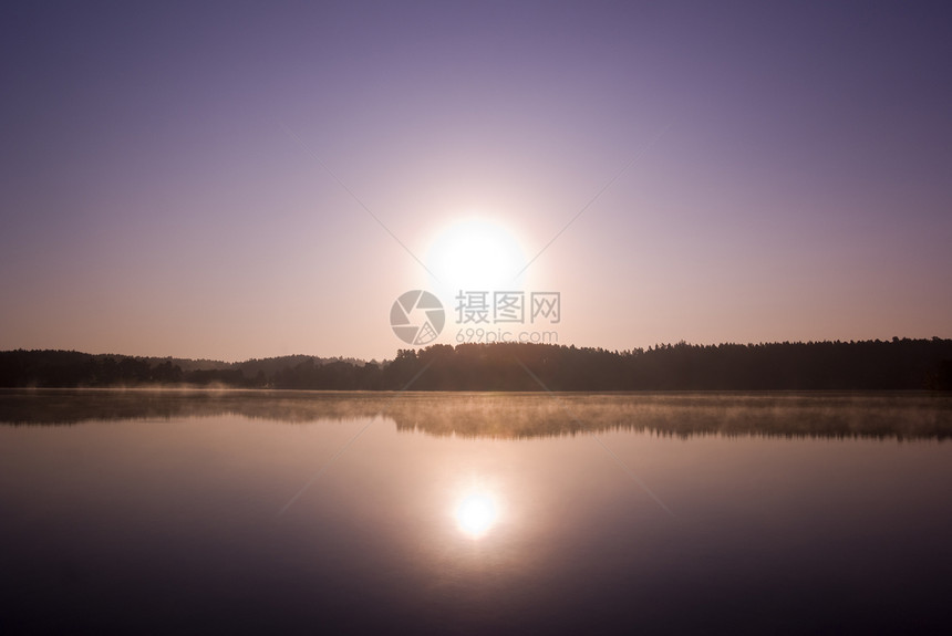 太阳升起天空海岸线日落蓝色场景反射海岸地平线薄雾风景图片