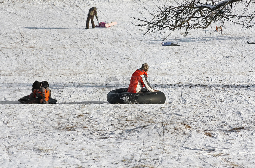 冬季儿童乡村橡胶管痕迹白色晴天山坡平底驾驶雪橇风景图片
