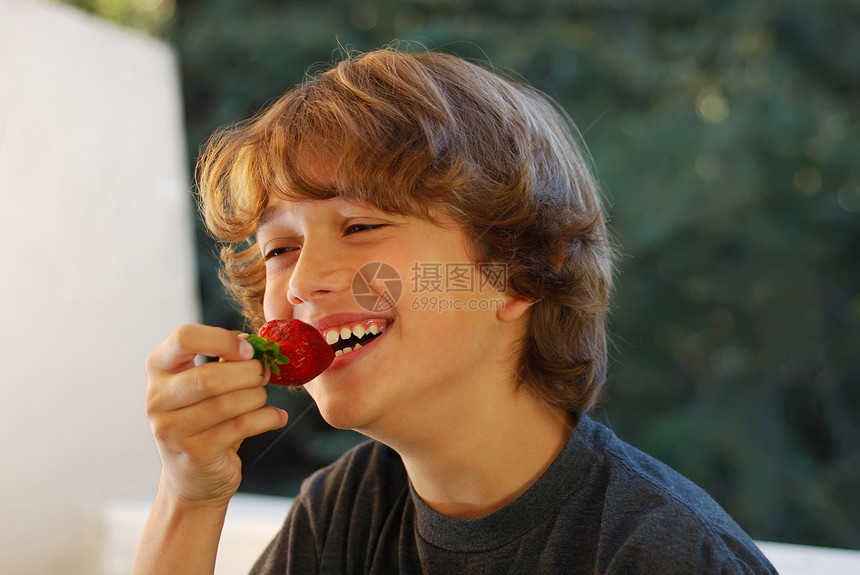 食用草莓的少年男孩图片