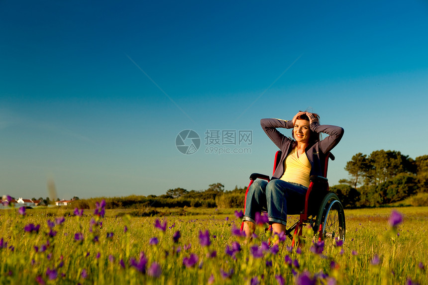 轮轮椅残疾妇女喜悦女性活动情感幸福椅子人士座位车辆草地图片