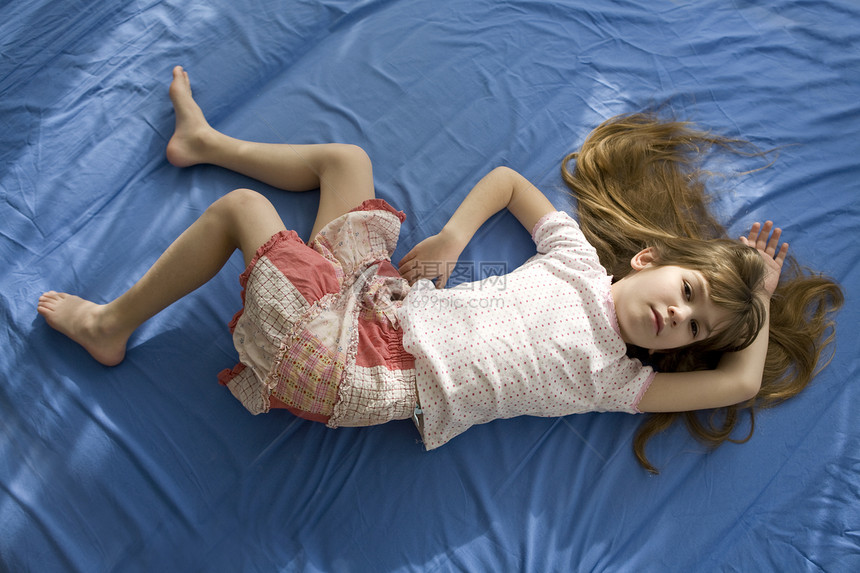 睡在床上的可爱小女孩 蓝棉布图片