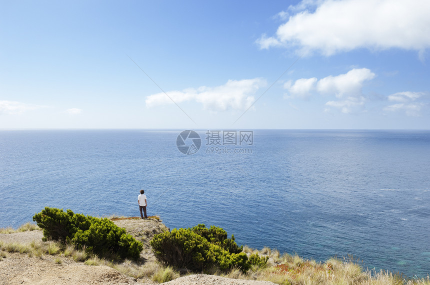 年轻人看着海洋沿海男性地平线天空海岸线边缘悬崖海景风景男人图片