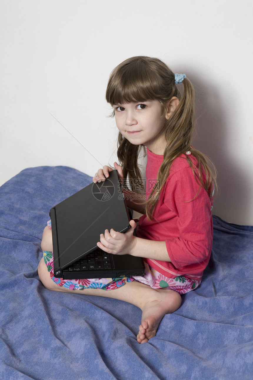 7岁的可爱小女孩玩电脑游戏的7岁女孩教育家庭作业网络孩子技术电脑幼儿园笔记本学习者智力图片