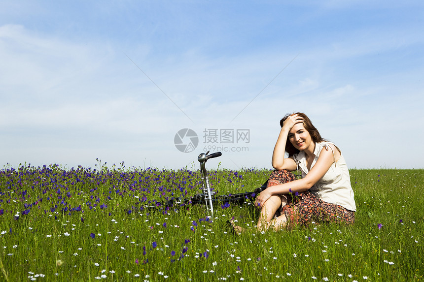 骑自行车的女孩场地女性微笑喜悦成人公园天空享受乐趣自由图片