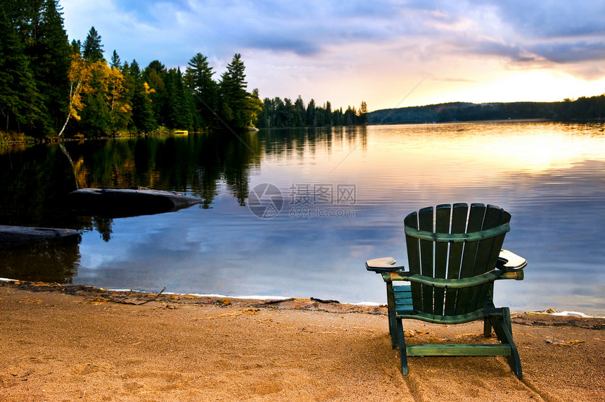 海滩日落时的木椅子日出小屋反思反射家具树木假期支撑风景天空图片